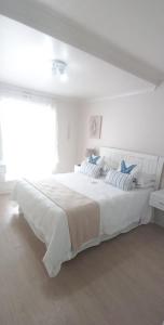 赫曼努斯Time To Unwind Unit 35的白色卧室配有白色大床和蓝色枕头