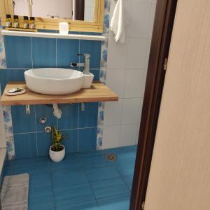 艾拉方索斯Kalomoira's Apartments的浴室设有白色水槽和蓝色瓷砖