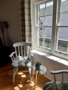 利马瓦迪Ballymultimber Cottages的一间带椅子和桌子的房间以及窗户