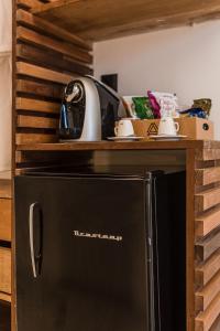 费尔南多 - 迪诺罗尼亚Triângulo Noronha的厨房里设有黑冰箱,配有木架
