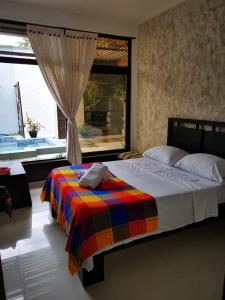 莱蒂西亚Casa amazilia的一间卧室配有一张带彩色毯子的床