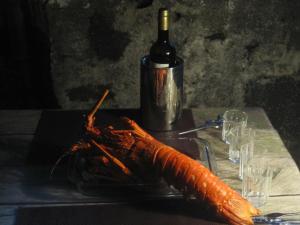ArcosCasa do Jardim de Lava的一瓶葡萄酒旁盘子上的龙虾