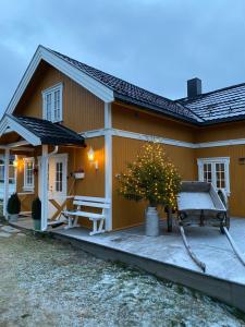 RingsakerGuesthouse 20 min from Sjusjoen, 30 min from Lillehammer and Hamar, 2h from Oslo的房屋前方有一座带树木的庭院