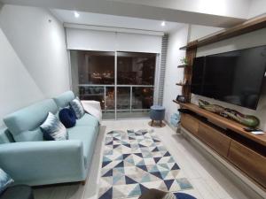 利马Epiqe Manuel Olguin 600的客厅配有蓝色的沙发和大电视