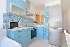 杜埃Apartment Duce 2737a的厨房配有蓝色橱柜和冰箱。