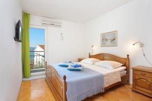 杜埃Apartments by the sea Duce, Omis - 2737的一间卧室设有一张床和一个大窗户