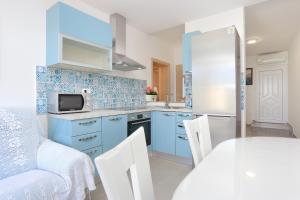 杜埃Apartments by the sea Duce, Omis - 2737的厨房配有蓝色橱柜和桌椅