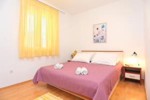 泰斯Apartments by the sea Stanici, Omis - 2764的一间卧室,床上有两双白鞋