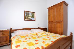 泰斯Apartment Stanici 2818d的一间卧室配有一张床和一个木制橱柜