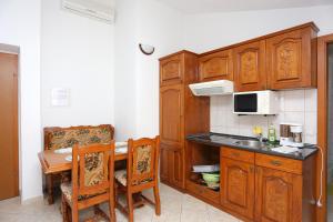 泰斯Apartment Stanici 2818d的厨房配有木制橱柜和带微波炉的桌子。