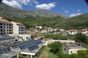 德尔韦尼克Apartments by the sea Drvenik Donja vala, Makarska - 2732的山前有太阳能电池板的城镇