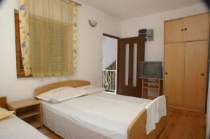 德尔韦尼克Apartments by the sea Drvenik Donja vala, Makarska - 2732的一间小卧室,配有一张床和电视