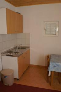 德尔韦尼克Apartments by the sea Drvenik Donja vala, Makarska - 2732的一个带水槽和桌子的小厨房