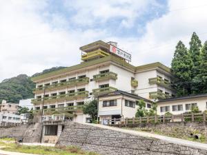 真庭市Tabist Spa Yubara Okayama Yubaraonsen的一座拥有石墙的酒店建筑