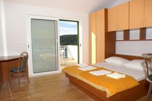 赫瓦尔Apartments and rooms by the sea Milna, Hvar - 3074的一间卧室设有一张床和一个滑动玻璃门