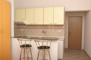 赫瓦尔Apartments and rooms by the sea Milna, Hvar - 3074的厨房配有2张吧台凳和白色橱柜