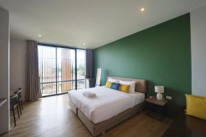 Lang SuanPugdee Hotel的一间卧室设有一张大床和绿色的墙壁