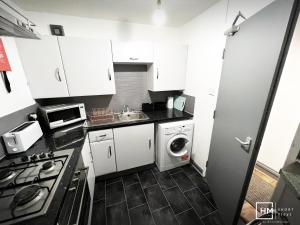 Enfield LockEnfield House - Beautiful 2 Bed - Good Transport Free Parking的小厨房配有白色橱柜、洗衣机和烘干机