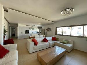 特拉维夫Beautiful 2-bedroom condo in the heart of Tel Aviv的客厅配有白色沙发和红色枕头。