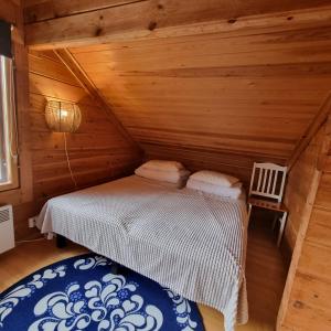 Kaamanen雷文图勒恩图帕山林小屋的小木屋内一间卧室,配有一张床