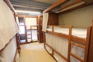 东京葡萄屋高圆寺旅舍的一间卧室配有两张双层床。