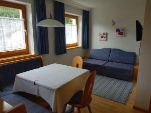 科尔福索Residence Majarai的客厅配有桌子和蓝色沙发
