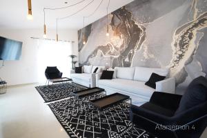 埃拉特YalaRent Afarsemon Apartments with pool - For Families & Couples的客厅配有白色沙发和黑色椅子
