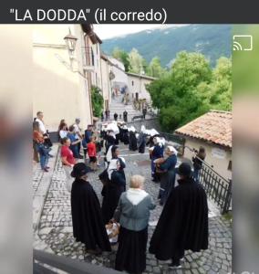 维勒塔巴雷亚Casa vacanze al Castello的一群穿着黑色衣服沿着街道走的人