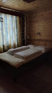 萨拉Kelomökki Sallatunturissa的木墙客房的一张床位