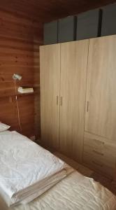 萨拉Kelomökki Sallatunturissa的一间卧室配有一张床和一个木制橱柜