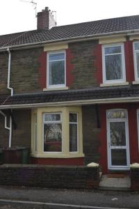 卡菲利Entire 3 bedroom house near Caerphilly station的街上的红砖房子,有白色窗户