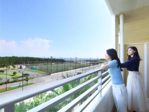 浦安东京湾普拉纳三井花园酒店的两名妇女站在一个眺望着大海的阳台