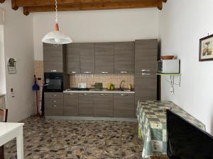 托雷拉皮罗Casa Alieta的厨房配有棕色橱柜和桌子