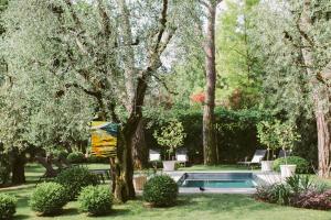 代森扎诺-德尔加达Hotel Piccola Vela的树木和灌木丛公园内的游泳池