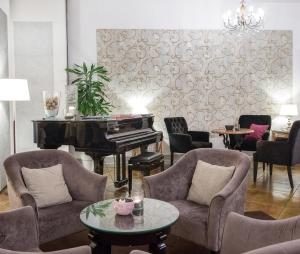 代森扎诺-德尔加达Hotel Piccola Vela的客厅配有钢琴、椅子和桌子