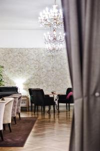 代森扎诺-德尔加达Hotel Piccola Vela的一间带吊灯和桌椅的用餐室