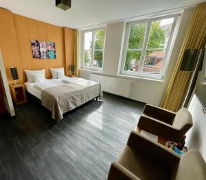 施特拉尔松德斯特拉松德海芬瑞斯登兹酒店的酒店客房带一张床、一把椅子和两个窗户