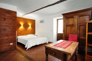Bussoleno伊尔穆利尼奥迪玛蒂酒店的卧室配有1张床、1张桌子和1把椅子