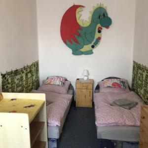 蒂萨菲赖德István Apartman的一间设有两张床的房间和墙上的龙