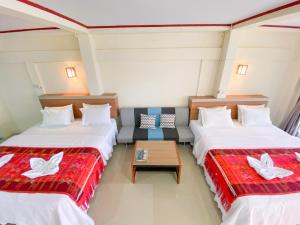 图克图克乐疆度假屋酒店的酒店客房,设有两张床和一张沙发