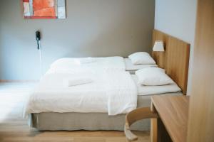 RamnäsNadden Hotell & Konferens的配有2张床的带白色床单和枕头的客房