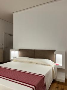 马达莱纳Dimora Elle的卧室配有一张带两个灯的大白色床