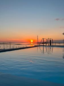格拉多Laguna Faro Suites - Adults Only & Free Beach的一座享有日落美景的游泳池