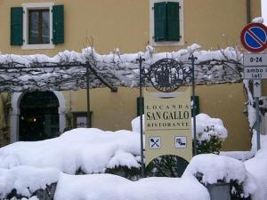 Moggio UdineseLOCANDA SAN GALLO的一座被雪覆盖的建筑,前面有标志