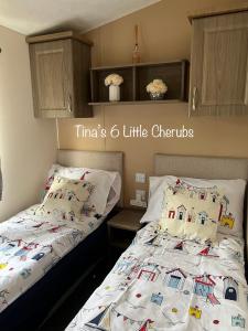 考斯6 Little Cherubs Holiday Home的一间卧室配有两张单人床和白色棉被