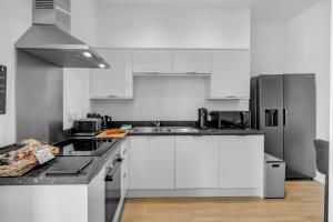 诺里奇Norwich Castle View Apt - Modern 2 Br的厨房配有白色橱柜和不锈钢用具