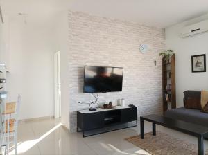 恰斯林נוגה בגולן的一间客厅,在砖墙上配有平面电视