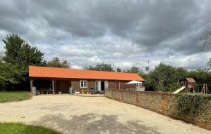 ToppesfieldWalnut Tree Cottage Barn的一座带橙色屋顶和石墙的房子