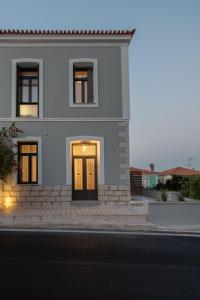 萨摩斯Villa Samos - Renovated stone villa with private pool- 2 min from the sea!的街上有门的白色房子