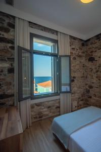 萨摩斯Villa Samos - Renovated stone villa with private pool- 2 min from the sea!的一间卧室设有一张床和一个大窗户
